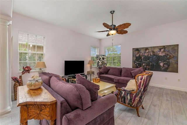 living room featuring decorative columns, light hardwood / wood-style flooring, and ceiling fan