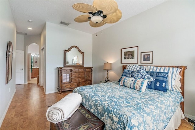 bedroom featuring a textured ceiling, connected bathroom, and ceiling fan