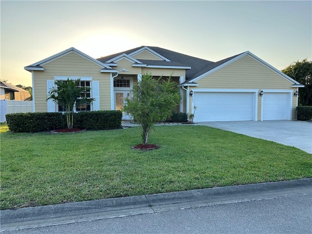 view of front of house featuring a garage and a lawn