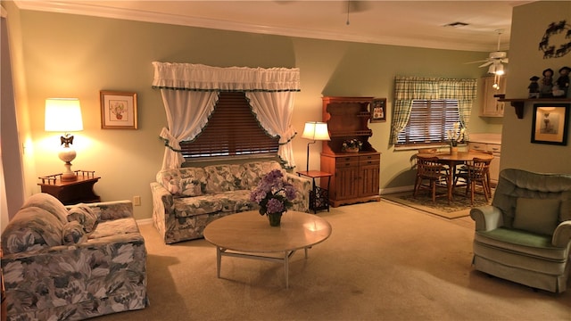 living area with ceiling fan, light carpet, and ornamental molding