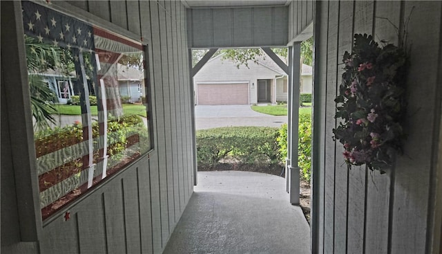 doorway with carpet and wooden walls