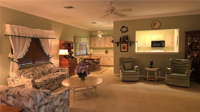 carpeted living room with ornamental molding and ceiling fan