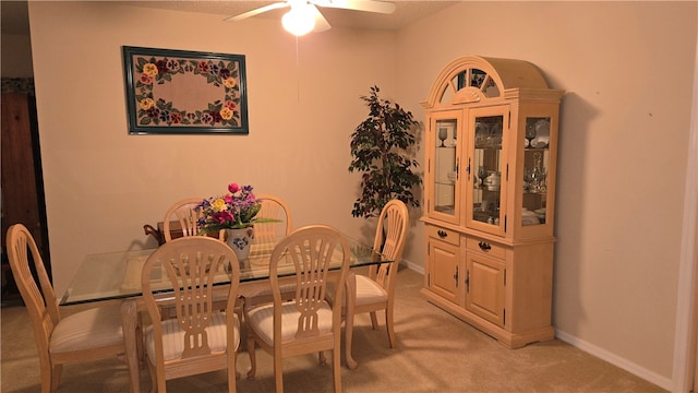 dining area with light carpet and ceiling fan