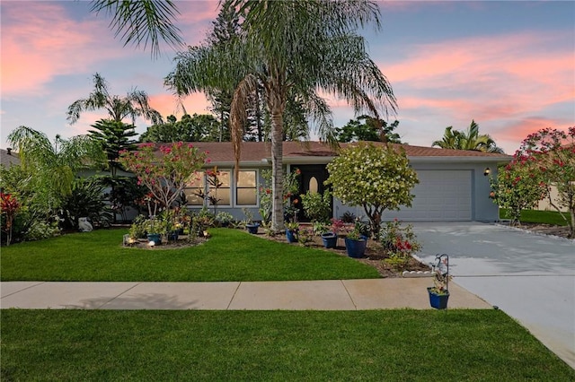 2033 Thistle Dr, Melbourne, FL 32935 - view of front of home with a lawn, stucco siding, driveway, and a garage