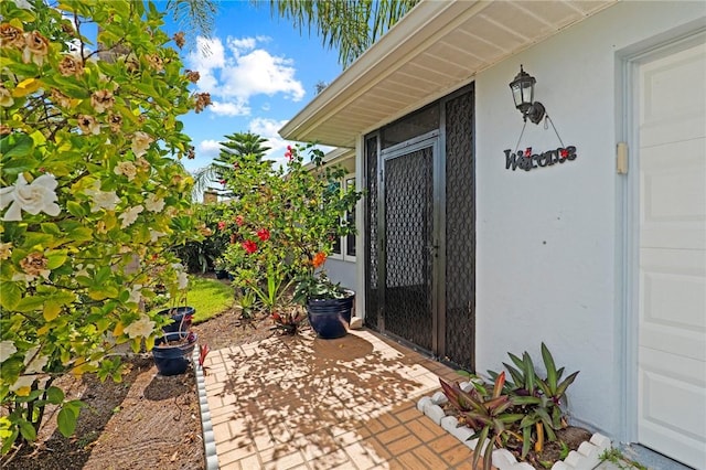 2033 Thistle Dr, Melbourne, FL 32935 - doorway to property with a patio area and stucco siding