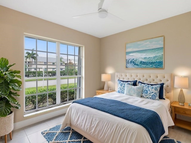 bedroom with light tile patterned floors, ceiling fan, and baseboards