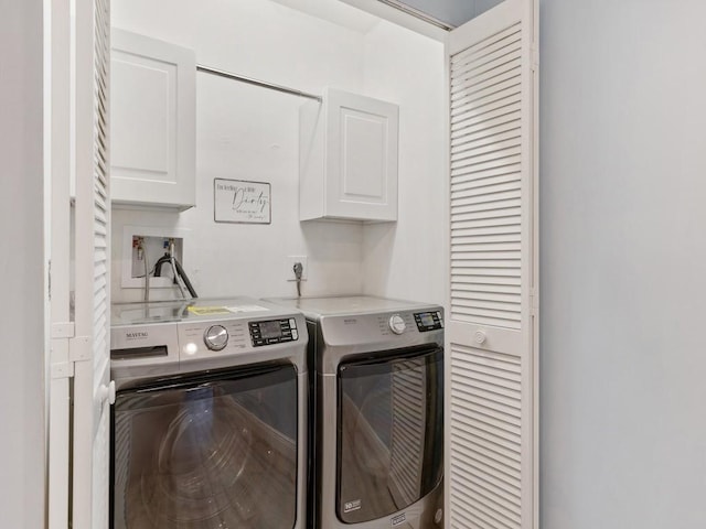 washroom featuring washing machine and dryer and cabinet space