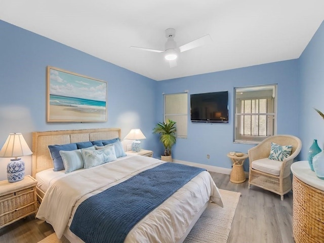 bedroom featuring ceiling fan, baseboards, and wood finished floors