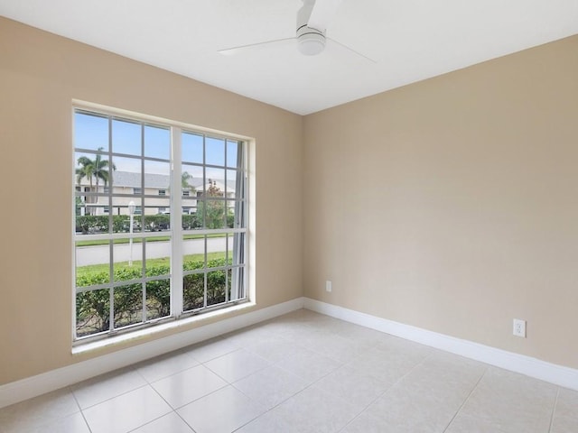 unfurnished room with light tile patterned floors, baseboards, and a ceiling fan