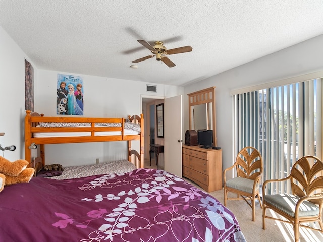 carpeted bedroom with a textured ceiling and ceiling fan