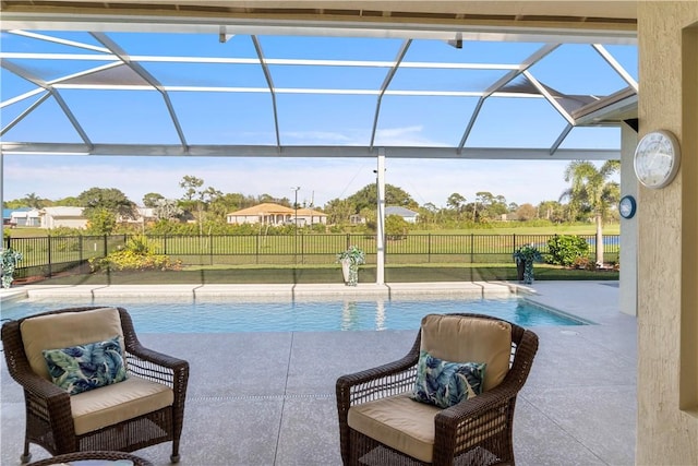 view of swimming pool with glass enclosure, a patio area, a fenced backyard, and a fenced in pool