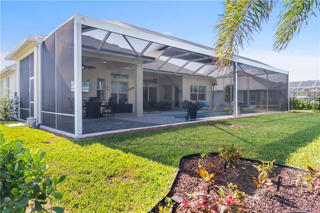 back of property featuring ceiling fan, a lanai, a yard, a patio area, and stucco siding