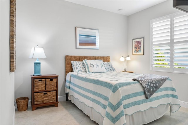 bedroom with light tile patterned floors and baseboards