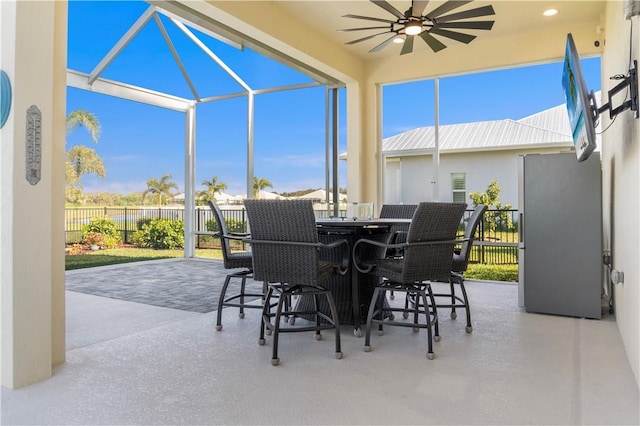 view of patio / terrace with outdoor dining space, a lanai, a ceiling fan, and fence