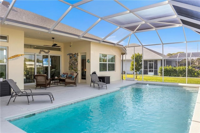 pool featuring ceiling fan, glass enclosure, a patio area, and an outdoor living space