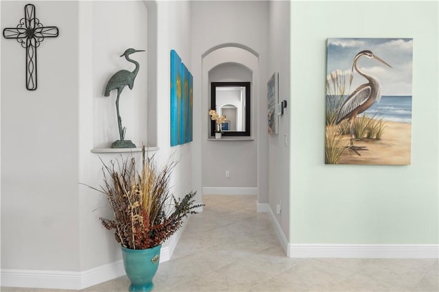 hallway featuring tile patterned flooring and baseboards