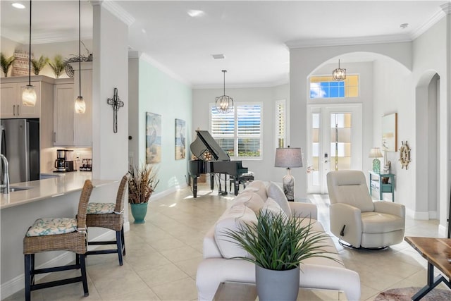 living room featuring light tile patterned floors, arched walkways, and ornamental molding