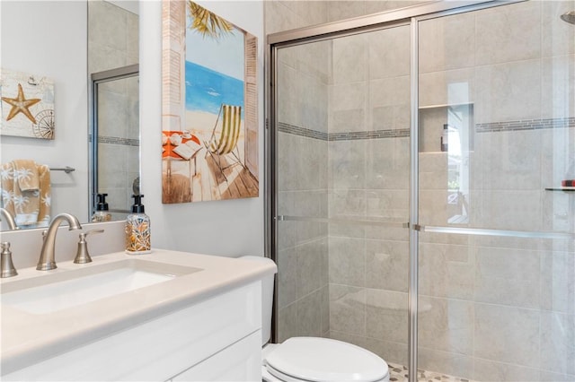 bathroom with a stall shower, vanity, and toilet