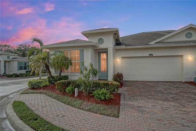 1819 Oak Grove Ct, Vero Beach, FL 32966 - view of front of home featuring decorative driveway, stucco siding, a garage, and a shingled roof