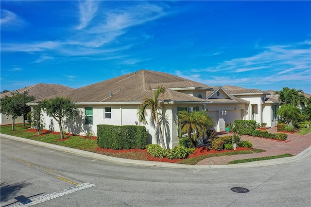 1819 Oak Grove Ct, Vero Beach, FL 32966 - view of front of house featuring a garage, stucco siding, and decorative driveway