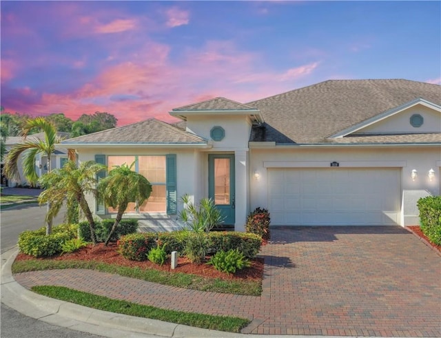 1819 Oak Grove Ct, Vero Beach, FL 32966 - view of front of house featuring stucco siding, decorative driveway, and a garage