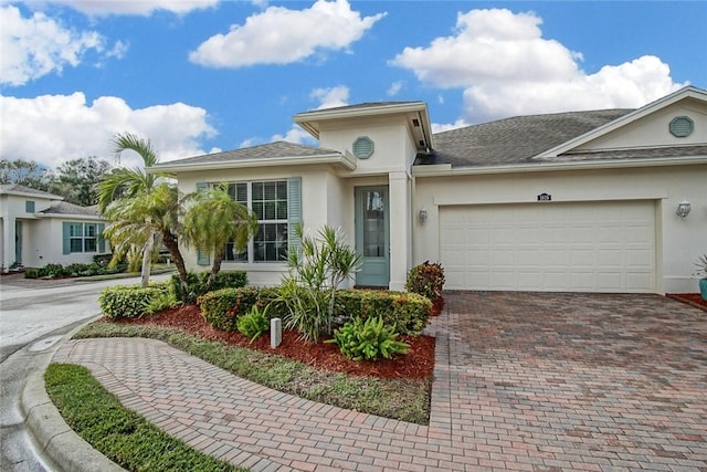 1819 Oak Grove Ct, Vero Beach, FL 32966 - view of front of house featuring decorative driveway, stucco siding, a garage, and roof with shingles