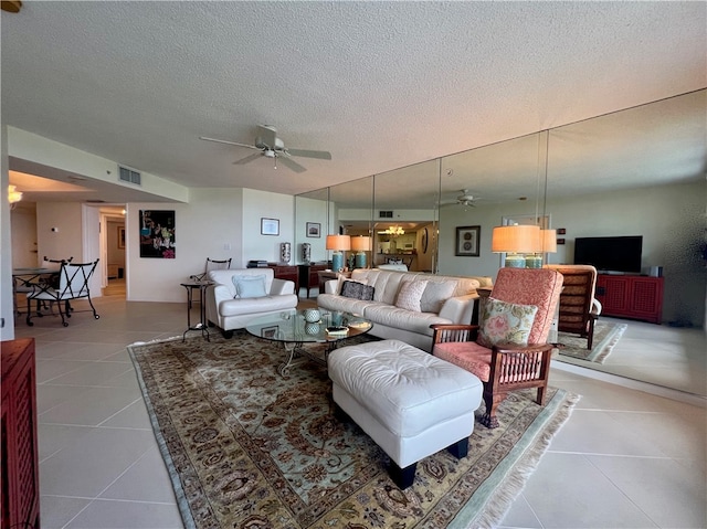 living room with a textured ceiling, tile patterned floors, and ceiling fan