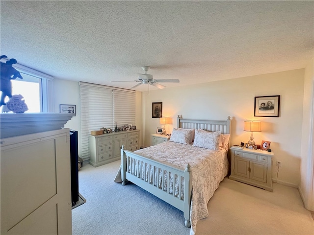 carpeted bedroom featuring a textured ceiling and ceiling fan