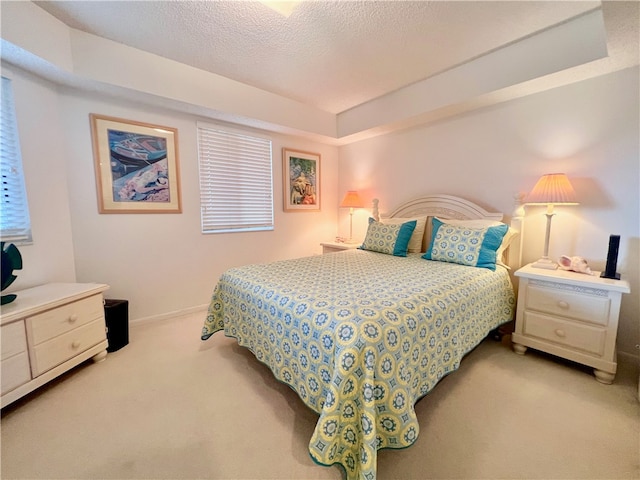 bedroom featuring a textured ceiling and light carpet