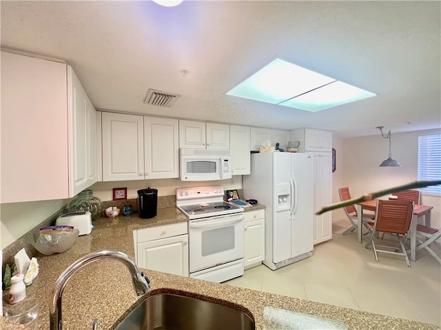 kitchen featuring white cabinets, sink, a skylight, pendant lighting, and white appliances