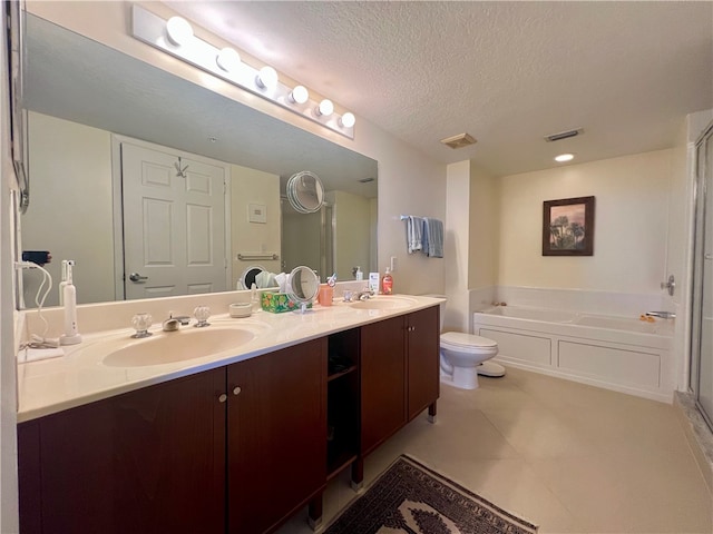 bathroom featuring a bathing tub, vanity, a textured ceiling, and toilet