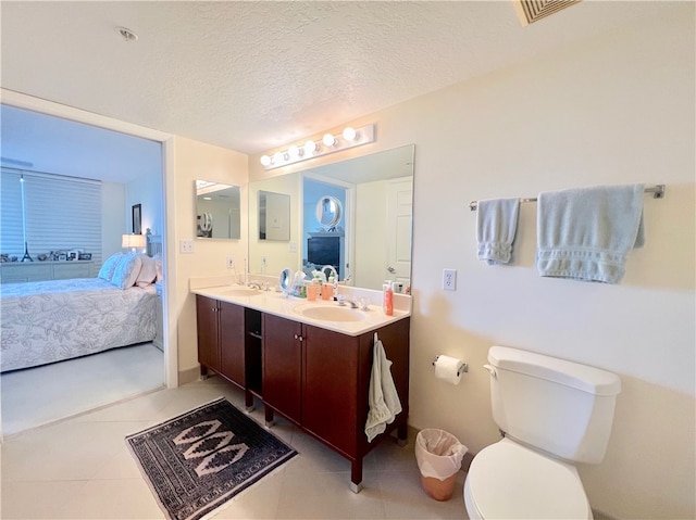 bathroom featuring vanity, tile patterned floors, a textured ceiling, and toilet