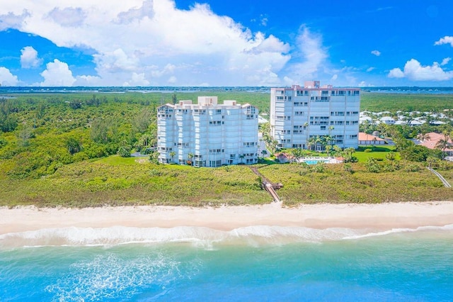 drone / aerial view featuring a water view and a view of the beach