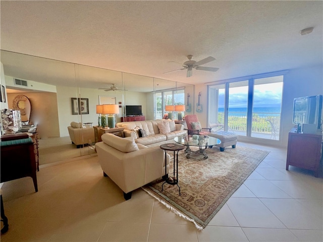 tiled living room featuring ceiling fan and a textured ceiling