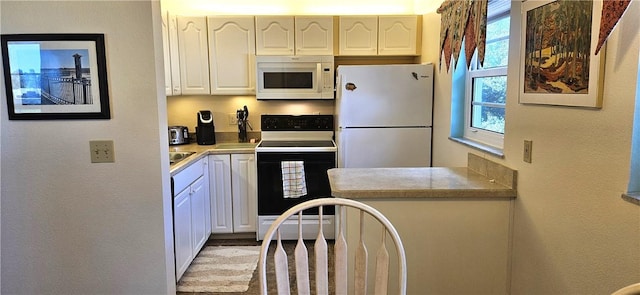 kitchen featuring white cabinets and white appliances