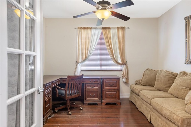 office area with dark wood-type flooring, a ceiling fan, and baseboards