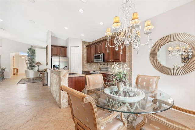 dining area featuring lofted ceiling, an inviting chandelier, light tile patterned floors, and recessed lighting