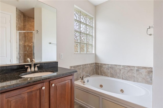 full bath featuring a stall shower, vanity, and a tub with jets