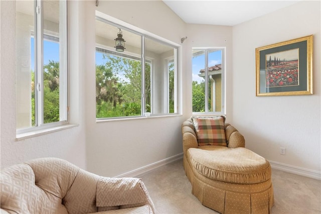 living area featuring light colored carpet and baseboards