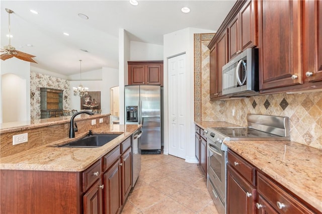 kitchen with tasteful backsplash, light stone counters, stainless steel appliances, pendant lighting, and a sink