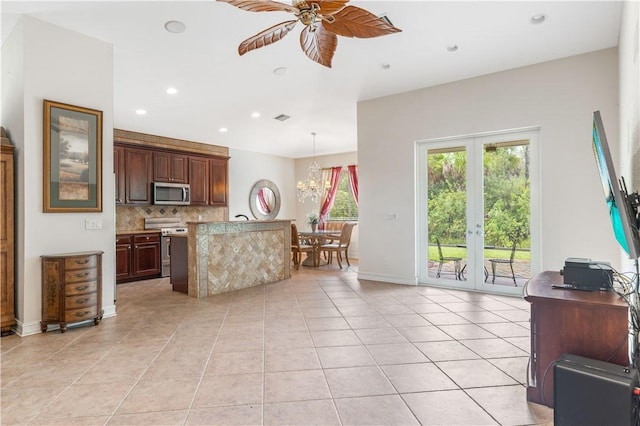 kitchen featuring ceiling fan with notable chandelier, stainless steel appliances, light countertops, tasteful backsplash, and decorative light fixtures