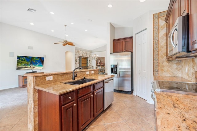 kitchen with light tile patterned floors, tasteful backsplash, lofted ceiling, appliances with stainless steel finishes, and a sink