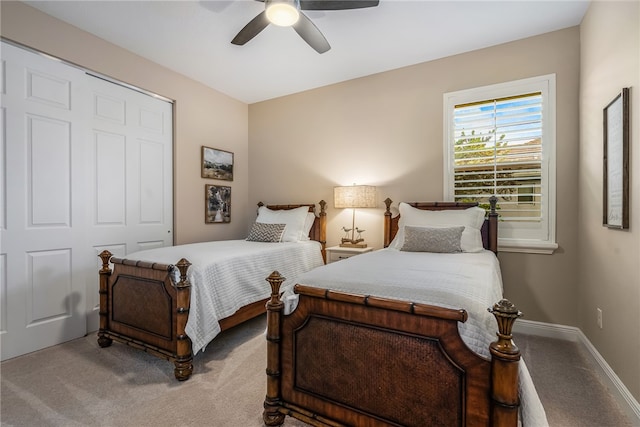 carpeted bedroom with ceiling fan and a closet