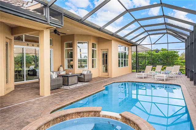 view of pool featuring an outdoor living space, glass enclosure, ceiling fan, an in ground hot tub, and a patio