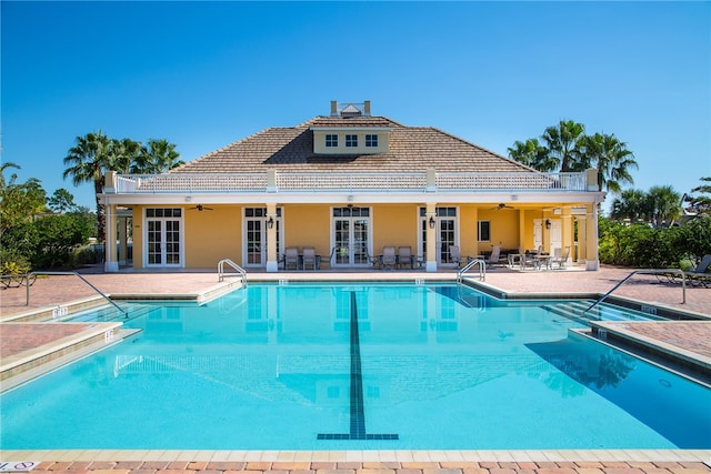 view of swimming pool with ceiling fan, french doors, and a patio