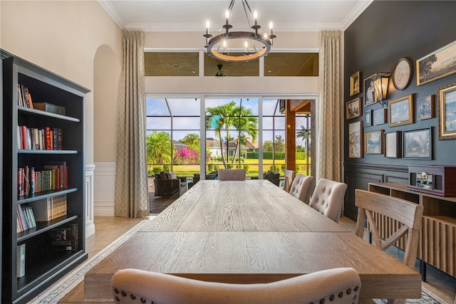 dining area with ornamental molding, light tile patterned floors, and an inviting chandelier