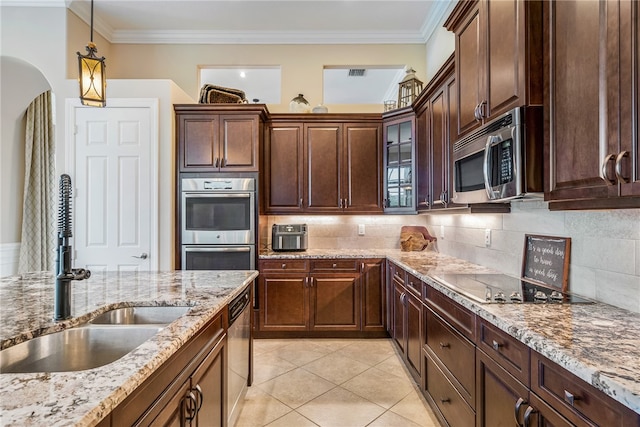 kitchen with crown molding, light tile patterned flooring, sink, and stainless steel appliances