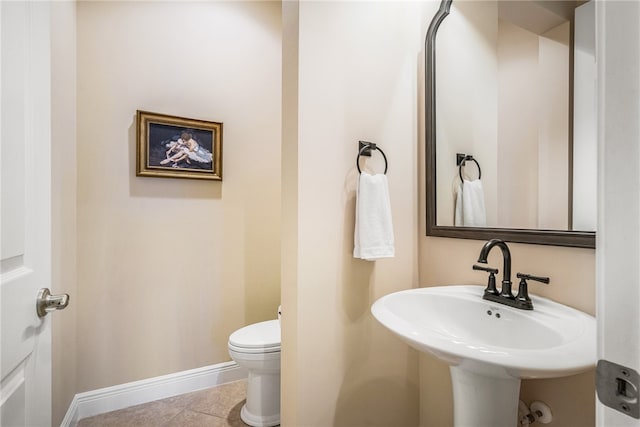 bathroom featuring toilet, tile patterned floors, and sink