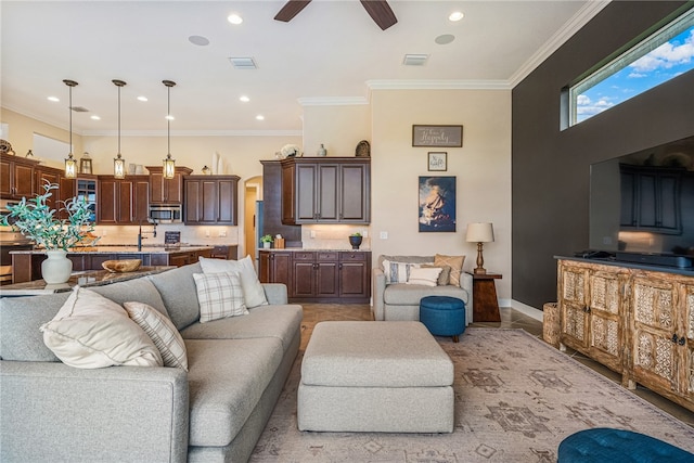 living room with ceiling fan and ornamental molding