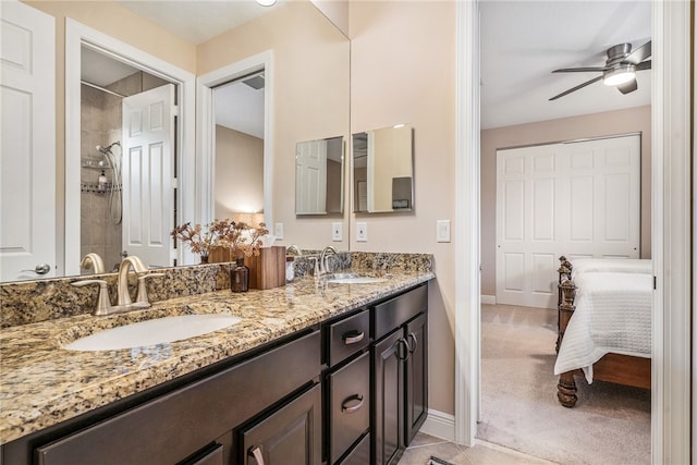 bathroom featuring a tile shower, vanity, and ceiling fan